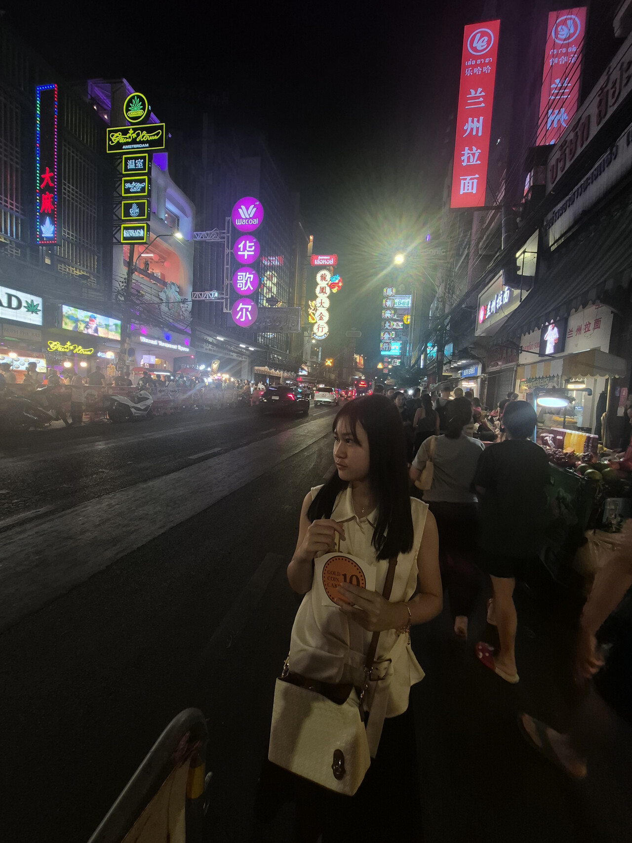 Traveler beside Yaowarat Road beneath neon signs at night